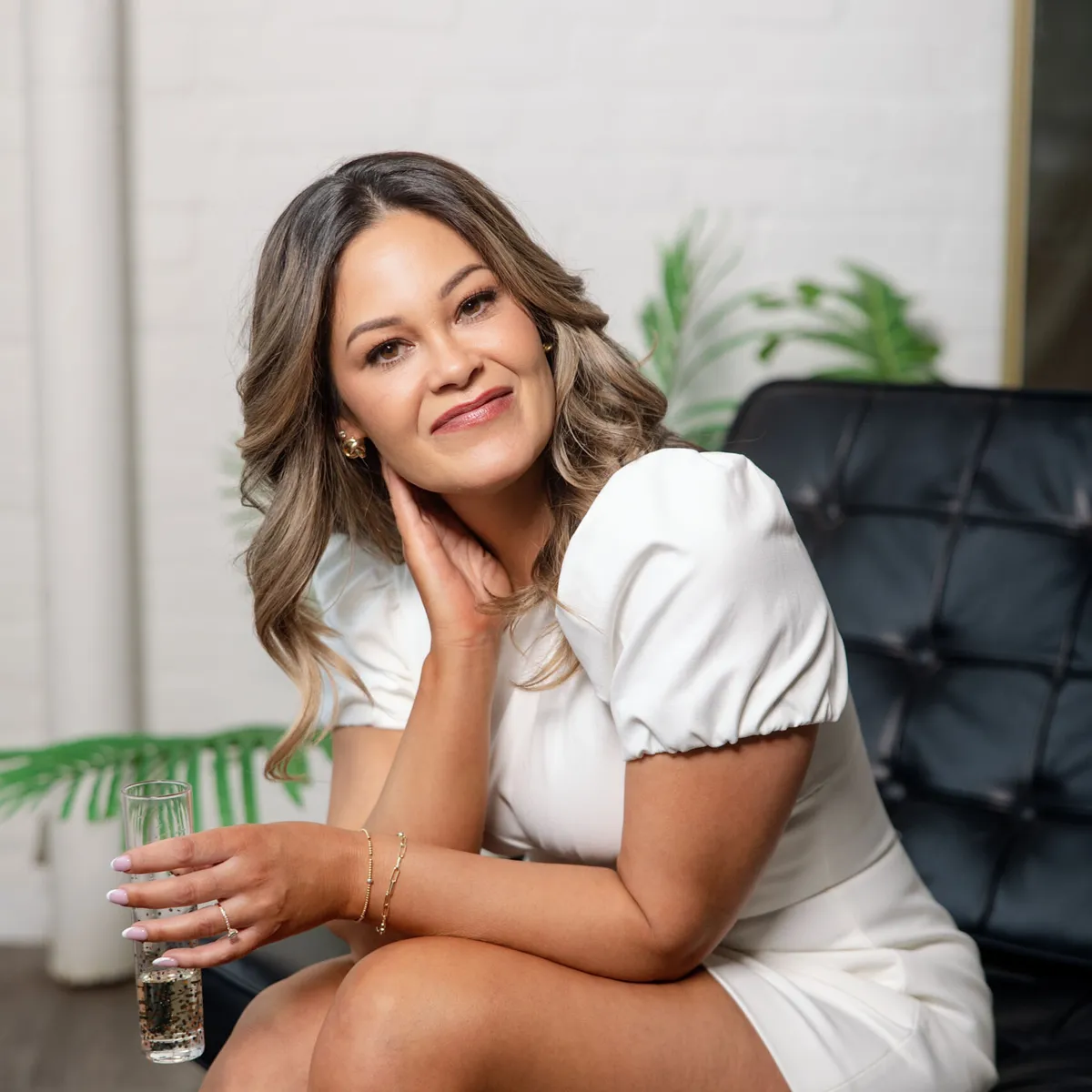 Bobbi Tanguay, dating coach, smiling in a leather chair at the Love Collective studio